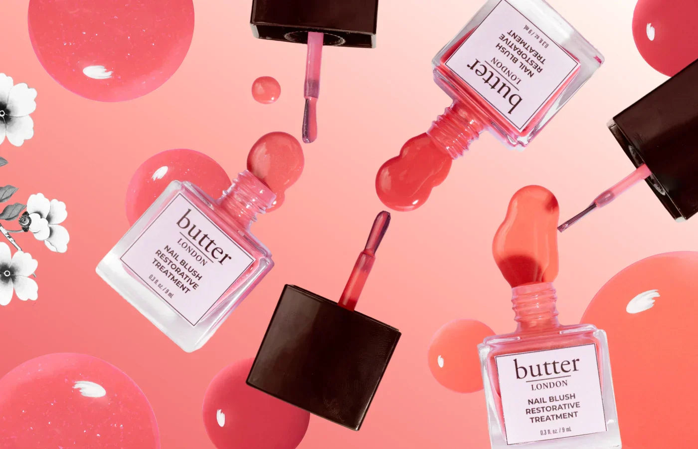 Flat lay of pink Butter London nail blush bottles with ribbons and pink droplets on a peach background