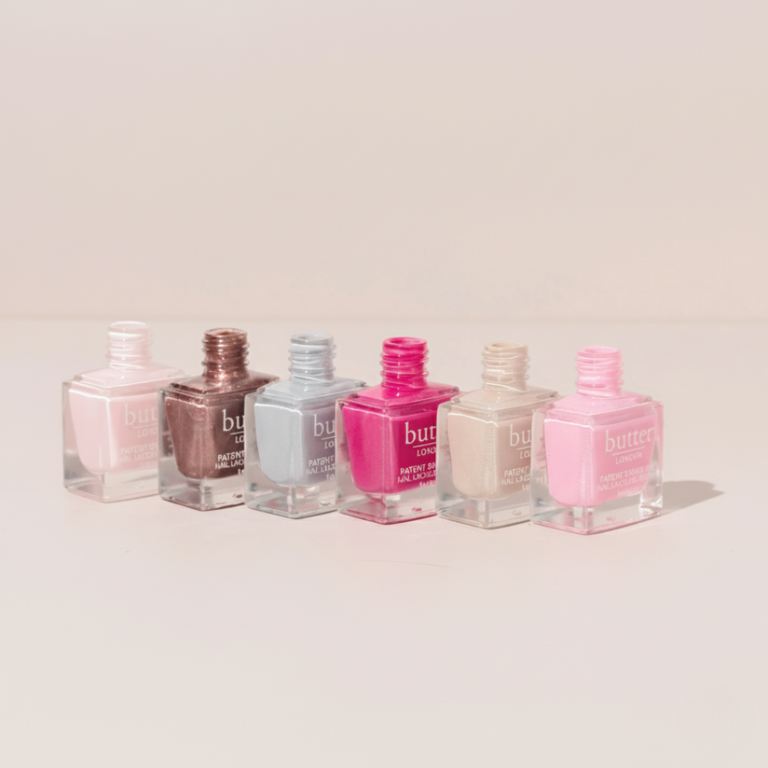 Butter London Cakes and Cuppas collection nail polishes in pastel shades arranged in a row on a white surface.