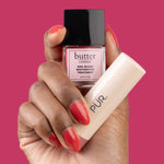 PÜR x butter LONDON Blush Crush - hand holding Cheeky Berry Nail Blush and Berry Best Silky Tint against pink background