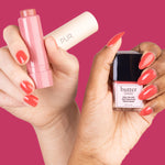 PÜR x butter LONDON Blush Crush - hands holding Berry Best Silky Tint and Cheeky Berry Nail Blush against pink background