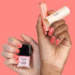 PÜR x butter LONDON Blush Crush - hands holding Coral Cosmo Silky Tint and Sunset Glow Nail Blush against coral background