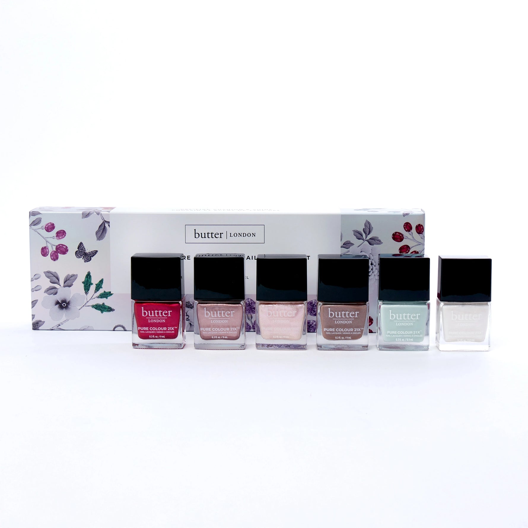 Holiday Sparkles 6-Piece PC21X set box with floral design and a row of black capped nail polish bottles in front.