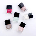 Assortment of various Pure Colour 21X Nail Lacquer colors laying flat against white background