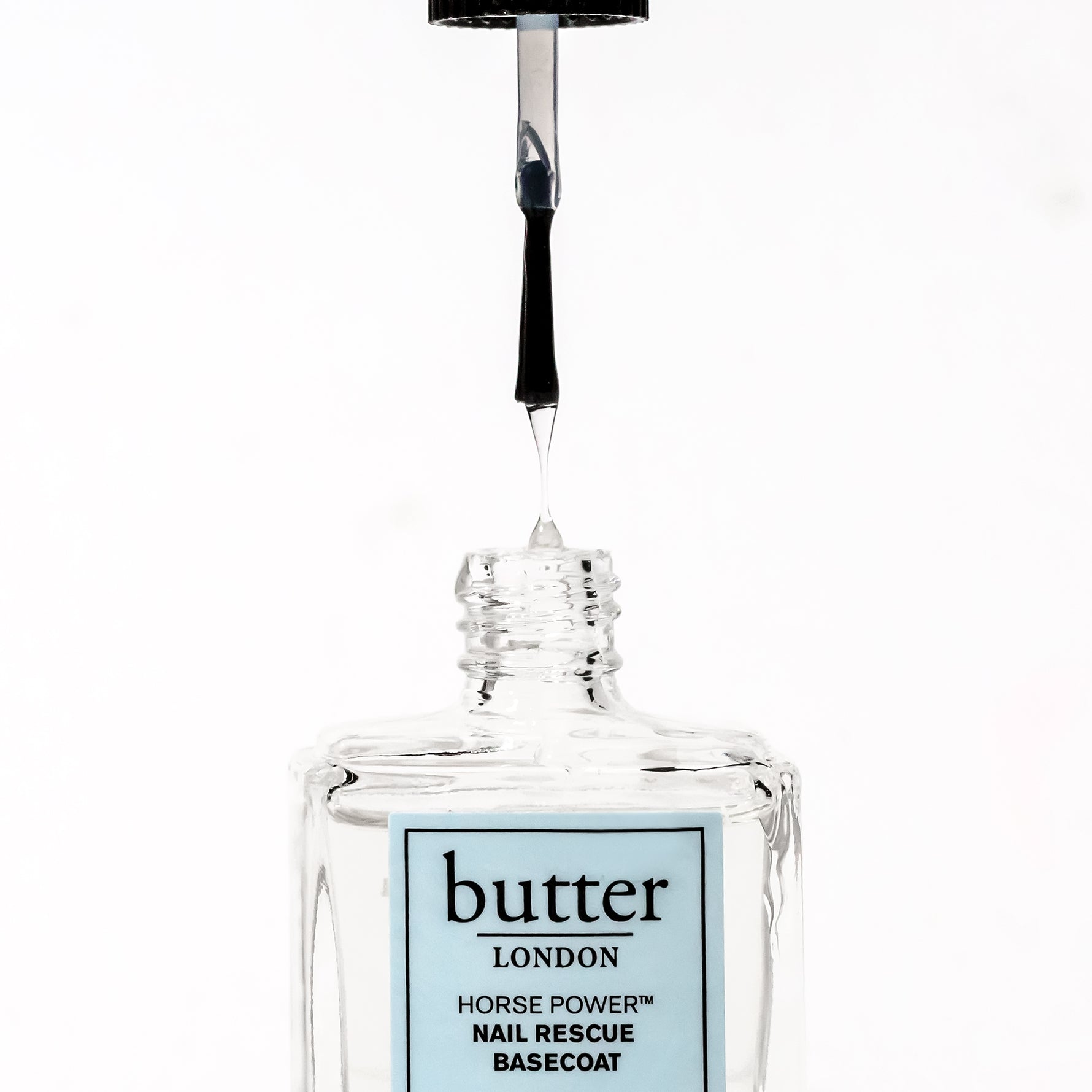 Butter London Horse Power Nail Rescue Basecoat bottle with brush poised above the opening