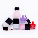 Six pastel Butter London nail lacquers from the Spring Candy set arranged in a stack with an open brush showcasing pink and purple shades