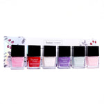 Butter London Pure Colour nail lacquers arranged in a row in front of floral packaging