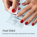 Butter LONDON Nail Scrubbers - Hand using a nail scrubber with text indicating dual-sided design on a light blue background