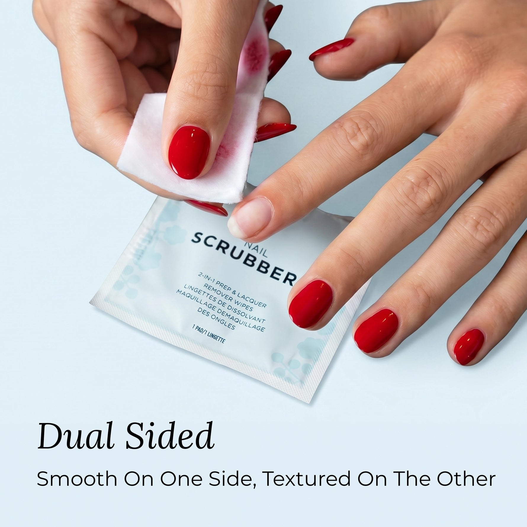 Butter LONDON Nail Scrubbers - Hand using a nail scrubber with text indicating dual-sided design on a light blue background