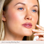 Close up of a woman with blue eyes and glossy pink lips wearing Blushing Rosé lip color.