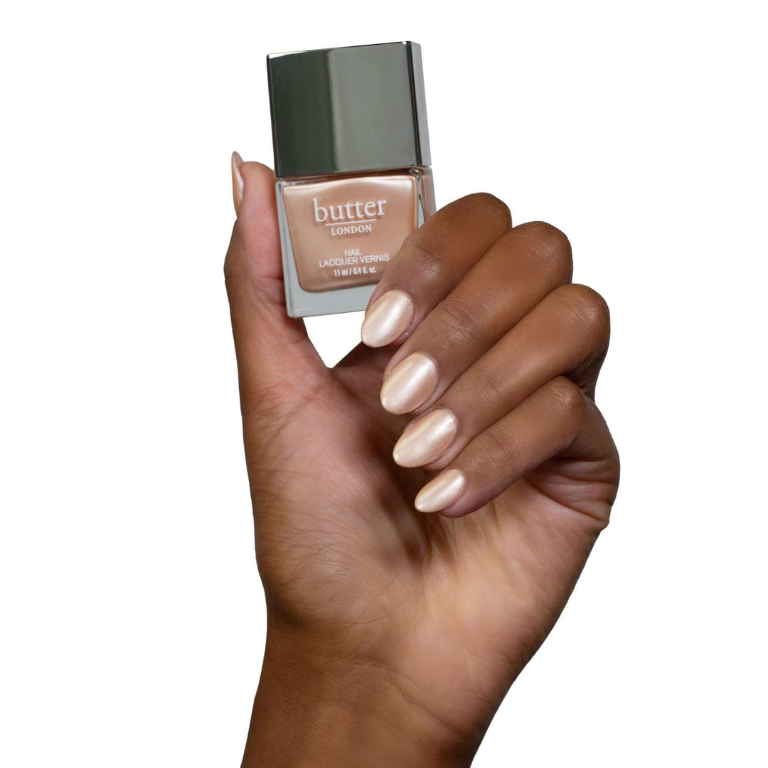 Hand holding Champagne Princess Patent Shine 10X Nail Lacquer (pearlescent champagne)